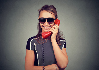 Happy young woman in sunglasses talking on a phone