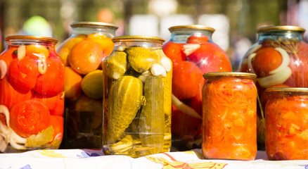 Fototapeta na wymiar canned cucumbers and tomatoes in glass jars