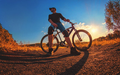 Fototapeta na wymiar caucasian athletic guy in a knee pads relies on a sports bike