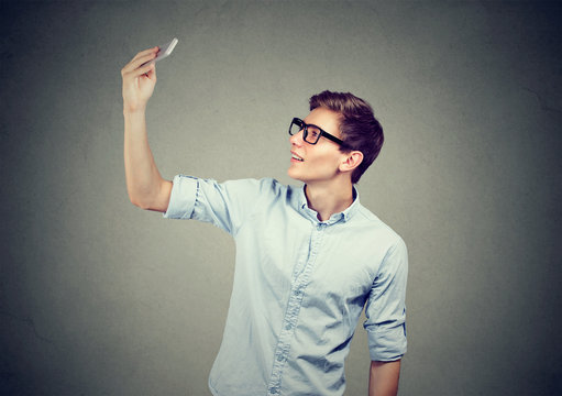 young man taking pictures of himself with smart phone