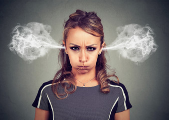 Closeup portrait of angry young woman, blowing steam coming out of ears