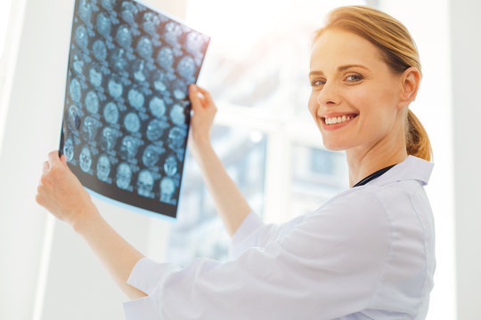 Cheerful medical professional posing with x ray scan picture