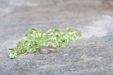 golden and silver wedding rings with green gems
