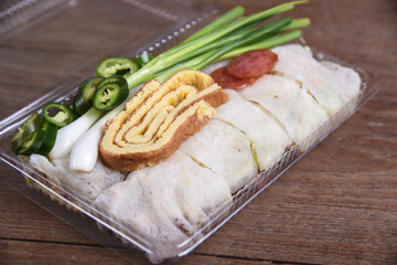 Fresh spring rolls , egg ,sausage wrap with flour topped with sauce and crab meat.
