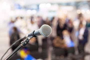 Microphone in focus against blurred audience. News conference.