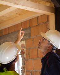 A female engineer shows the problem to the chief of the building site