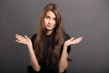 So what, Who cares. Unsure doubtful girl shrugging her shoulde