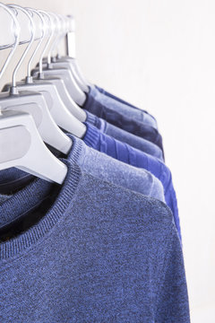 Men's sweaters on hangers in the store