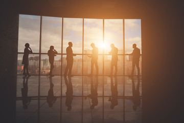 Group of Business People Discussing at Sunset Reflected