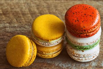 Close up colorful French macaron or Italian macaron. Homemade delicious macaron stack on wood table with copy space for background or wallpaper macro concept. French dessert served with tea or coffee.