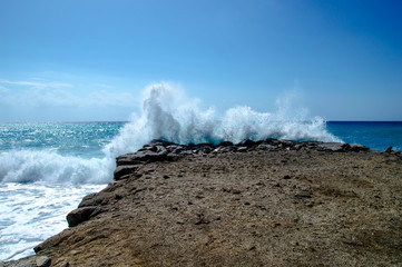 Waves break about a stone pier