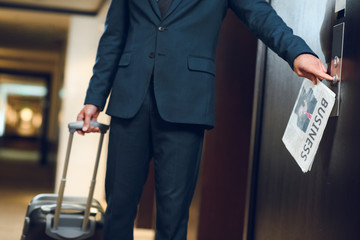 Businessman with suitcase calling elevator