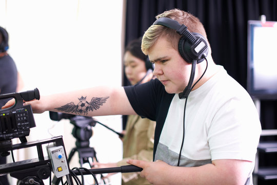 Male and female college students filming in TV studio