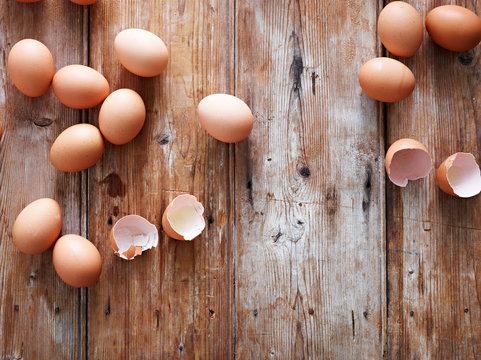 Eggs and egg shells on wooden surface, overhead view