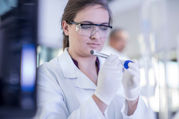 Laboratory worker writing details on test tube