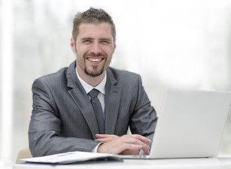 closeup.smiling businessman working with laptop