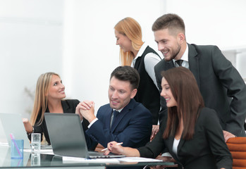 business team discussing new information , standing in front of the open laptop