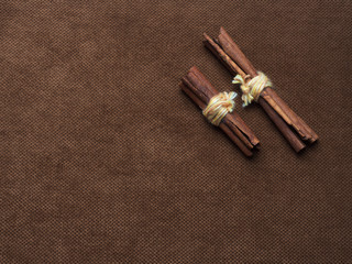 Obraz na płótnie Canvas Cinnamon sticks tied with string. On a nice brown background with a place for the inscription on the left.
