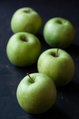 Green apples on a black background