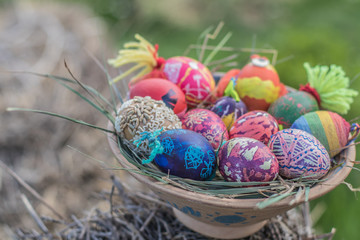 Happy easter modern colorful eggs handmade pottery plate grass chamomile daisies meadow outside