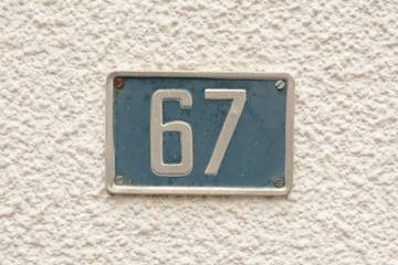 House number 67 sign on wall