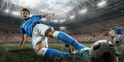 Soccer players performs an action play on a professional stadium. Two football teams fighting for...