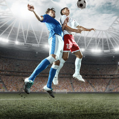 Soccer players performs an action play on a professional stadium. Two football teams fighting for the ball. Players wears unbranded sport uniform. © Alex