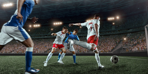 Soccer players performs an action play on a professional stadium. Two football teams fighting for...
