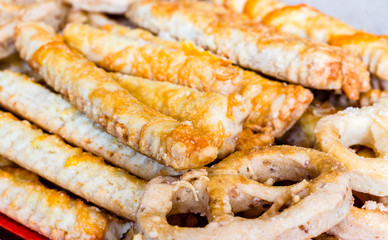 Traditional baked Hungarian salted pretzels in the traditional looped knot shape and sticks with cheese in a random heap