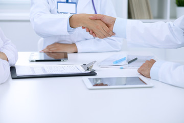 Doctors shaking hands to each other finishing up medical meeting