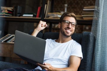 Cheering man using laptop