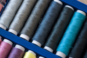 Close-up on colored sewing threads on spools