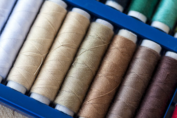 Close-up on colored sewing threads on spools