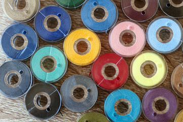 Close-up on colored sewing threads on spools