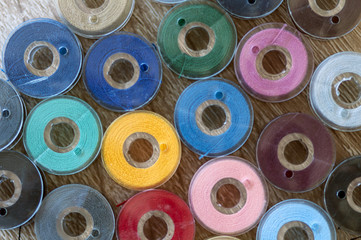 Close-up on colored sewing threads on spools