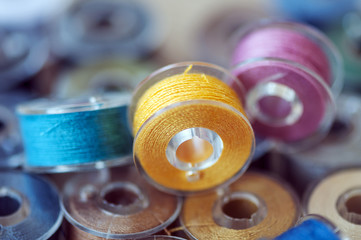 Close-up on colored sewing threads on spools