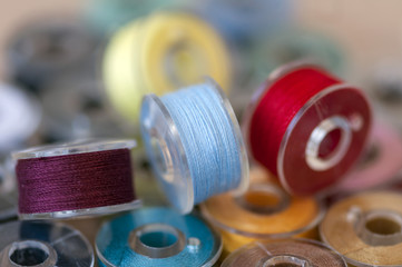 Close-up on colored sewing threads on spools