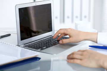 Close up of business woman hands typing on laptop computer