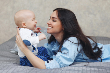 Happy young mother with the baby talk with a smile