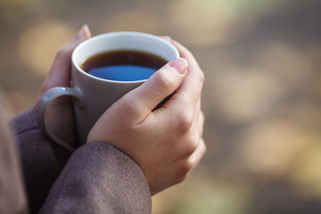 Girl in sweater holding a cup of coffee