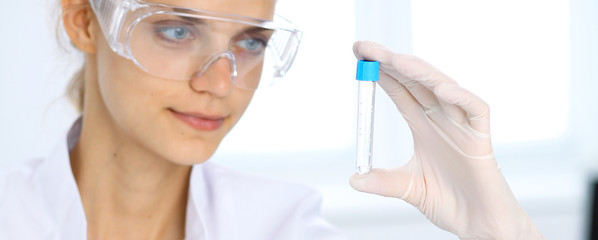 Female scientific researcher in laboratory studying substances or blood sample. Medicine and science concept