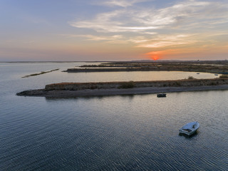 Sunset aerial seascape view of Olhao salt marsh Inlet, waterfront to Ria Formosa natural park. Algarve.