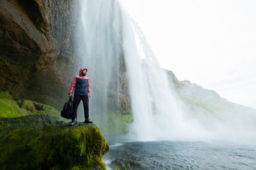 Obraz premium Przygoda mężczyzna skogafoss siklawą, natura na Iceland. Młody człowiek odwiedza krajobraz przyrody.