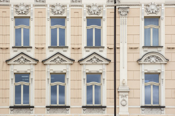 Eight Windows on the facade of the old vintage beige house