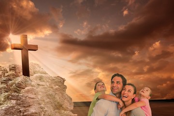 Composite image of happy young family looking up together