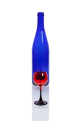 A bottle of blue glass with a red wineglass on a white background.