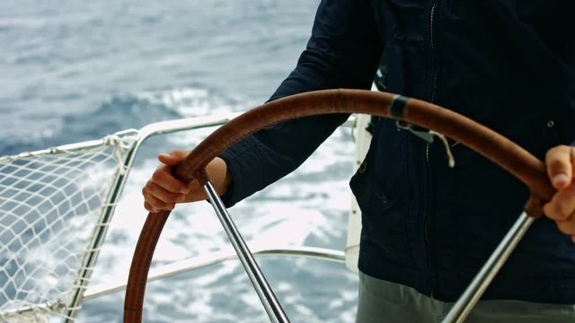 Man steering a yacht