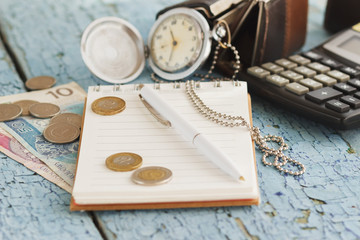 Polish zloty, wallets, pocket clock, notebook and calculator, wooden background