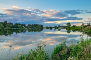 Beautiful summer landscape. Pond in the countryside in fabulous evening colors.