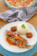Grilled fish served with rice and veggie